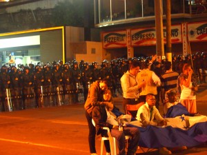 Through the police fence, the hunger strikers isolated inside are defiant in front of the wall of police