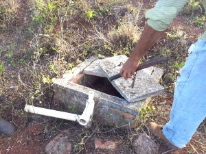 Coop members show me parts of the sabotaged water supply - now dry after  valves have been removed and pipes cut